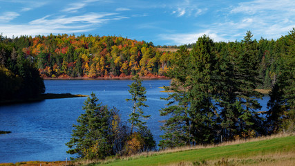Fototapeta na wymiar Fall foliage along a river in rural Prince Edward Island, Canada.