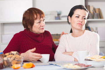 Portrait of sad mature woman talking with daughter