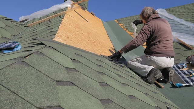 soft roof of shingles. Repair of the roof of a residential house. installation of soft tiles. partial replacement of the damaged roof. Dot repair. Nailing roofing material to the surface of the
