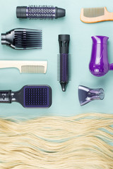 Hairdressing tools and hair extensions on blue wooden background. Top view