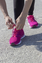 Girl laces up pink running shoes