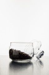 coffee grains in a glass vase on the table on a white background