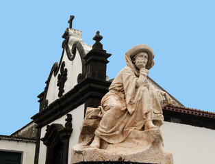 Fototapeta na wymiar Marble stature and church façade with Baroque architecture, Vila Franca do Campo, São Miguel, Portugal