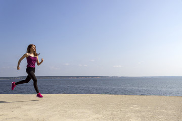Young fit girl running and training on the beach