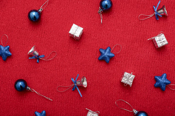 Beautiful Christmas toys of blue and silver colors on red knitted fabric background