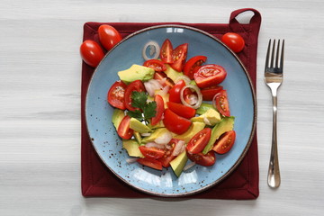 Fresh, healthy salad with tomatoes, avocado and onion.