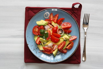 Fresh, healthy salad with tomatoes, avocado and onion.