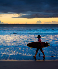 Woman surfer at sunset. Bali
