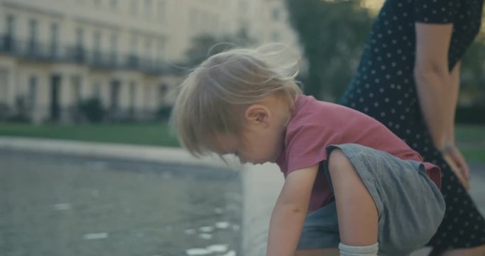 Young woman and toddler relaxing by fountain