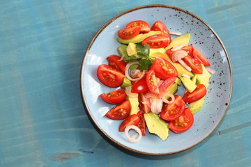 Delicious salad with tomatoes, avocado and onion.