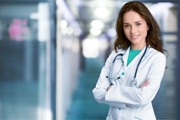 Young female doctor with stethoscope on blurred hospital