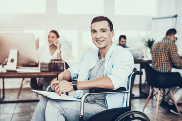 Disabled Man on Wheelchair with Tablet in Office.