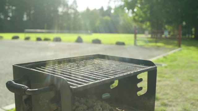 daylight 4k shot of a used bbq grill in an empty park