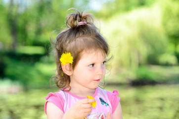 Portrait of a small three year old caucasian girl in a park