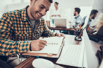 Young Man on Wheelchair Making Notes in Notebook.