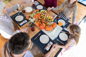 Vegetarian menu. Kind little girl sitting in semi position and looking at colorful pumpkins