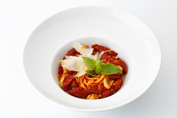 pasta with sausages and mushrooms and cheese in a large white plate isolated on white background