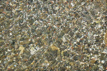 Top view of pebble stones under water background