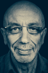 Closeup portrait of senior smiling man businessman with glasses in black and white