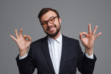 Relaxed adult businessman showing OK gestures