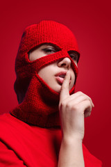 Woman in mask showing silence gesture