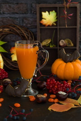 Fresh pumpkin juice on dark Halloween background with gingerbread cookies, selective focus with shallow depth of field