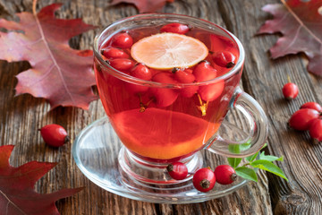 A cup of rose hip tea with fresh rose hips