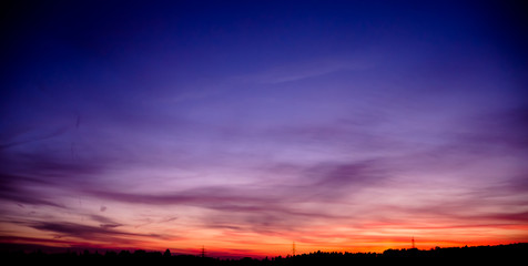 Naklejka premium Sonnenuntergang in Blau und Rot mit Stadt Umrissen