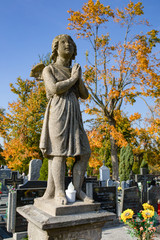 Old figurine, statuette of an angel. Colorful polish cemetery in the autumn sun. All Saints' Day....
