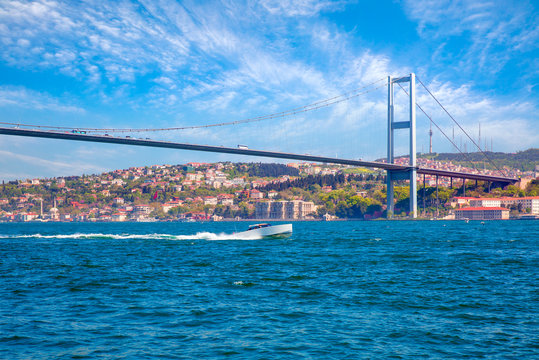 Fototapeta Luxury retro style wooden motor boat on the water next to the bosphorus bridge - Istanbul, Turkey