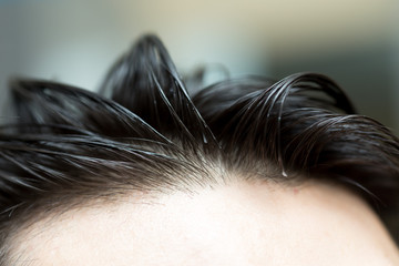 hair combed back to a young man's head close-up