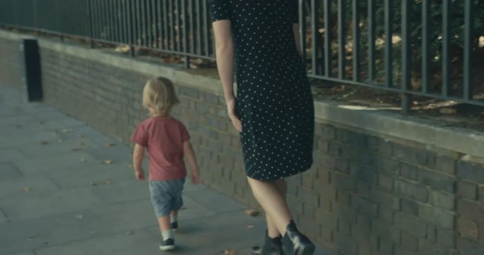 Young woman and toddler walking in the street