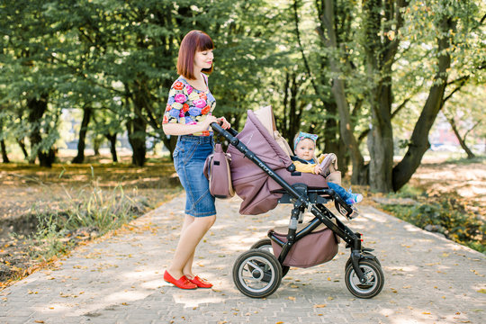 mother at outdoor shakes a baby carriage at spring or autumn season with large copy space for any text