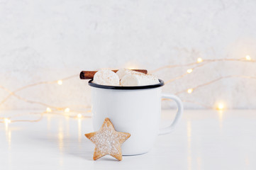 White mug of hot cocoa with marshmallow and cookie