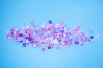 Multicolored confetti and sparkles on blue background.