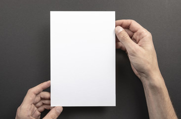 Mens hands holding white letterhead