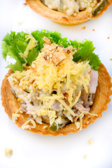 Tartlets with delicious cheese, pork, cucumber and nuts with lettuce
