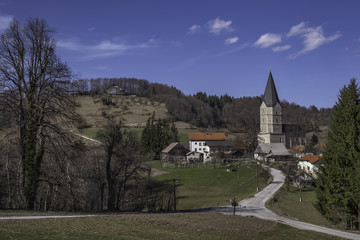Fototapeta na wymiar Small village Svetina near Celje with big gothic Holy Mother church, Slovenia