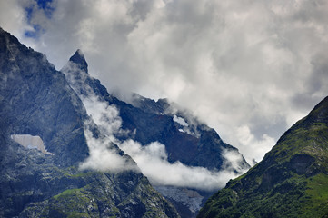 Peak of the mountain with glaciers against the background of clouds and sky. Caucasian ridge,...