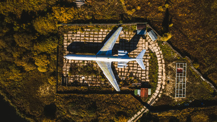 Aerial view of the plane in the autumn forest. Top view. Beautiful autumn landscape with a plane.