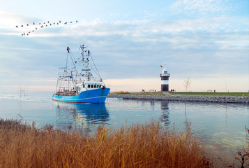 Krabbenkutter kommt zurück in den Heimathafen, Kutterhafen in Wremen mit Leuchtturm an der Wurster Nordseeküste 