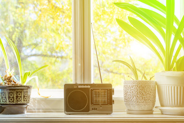 old retro radio with antenna on the window at home playing music f