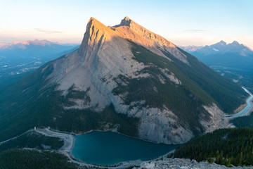 The last orange light catches the rugged edges of a distant point just before the sun sets