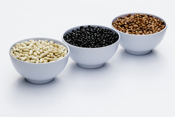 varieties of beans in bowls, white background