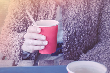 girl holding a red paper Cup of coffee