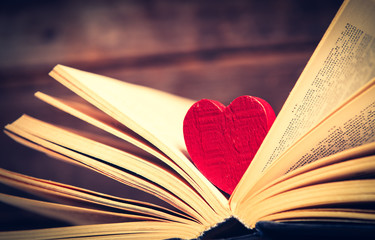 photo of the old books and heart shaped toy on the brown wooden background