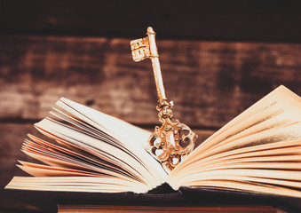 photo of the old books and key on the brown wooden background