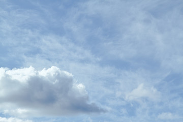 Blue sky filled with cirrus clouds and one cumulus cloud in the lower left.