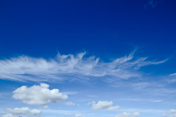 Blue sky, upper half clear, lower half with puffy cumulus clouds.
