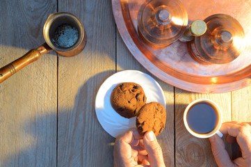 hands take coffee and biscuits from wooden rustic